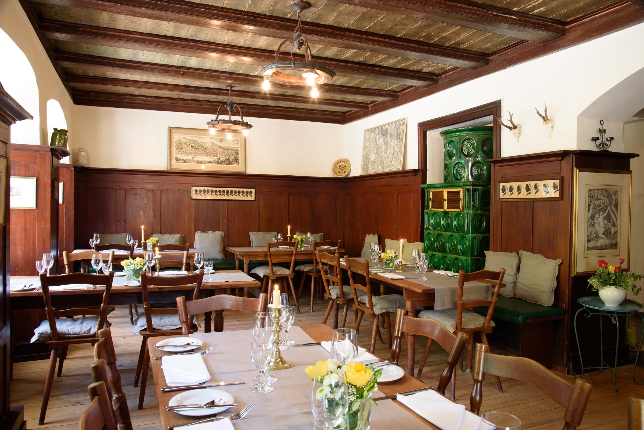 Stube im Restaurant Wolfsbrunnen mit eingedeckten Tischen und Kachelofen
